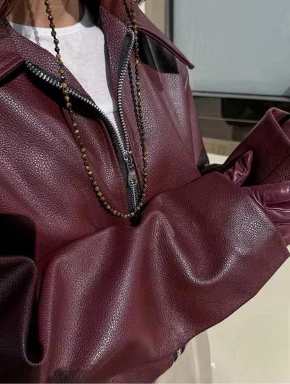 Veste en cuir synthétique à manches longues avec fermeture éclair sur le devant.